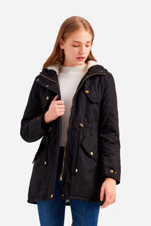 Woman wearing black extra comfortable cotton parka coat with fluffy hood and metal zipper