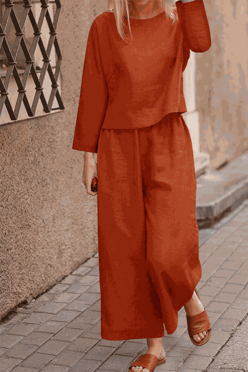 Woman wearing loose solid color two-piece set with long sleeves and wide-leg pants in autumn setting
