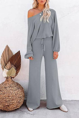 Woman wearing gray round neck loose fit cozy two-piece set with wide-leg pants and off-shoulder top