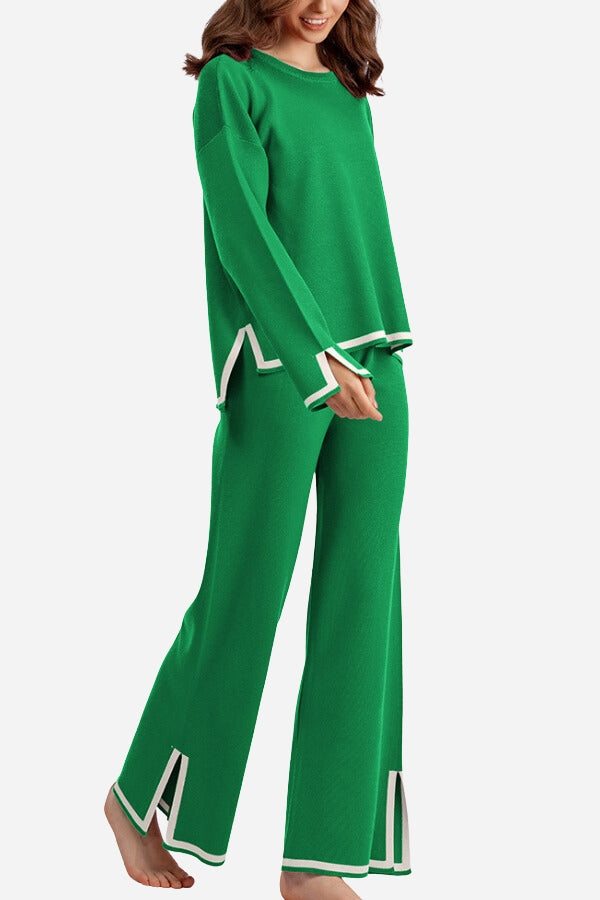 Woman wearing green long sleeved relaxed fit lounge two-piece set with white trim and wide-leg palazzo pants