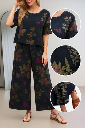 Women wearing a black floral loose fit co-ord set with wide short sleeves and wide-leg trousers, styled with sandals