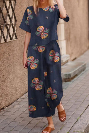 Woman wearing navy blue loose fit co-ord set with colorful floral prints and wide-leg pants on street