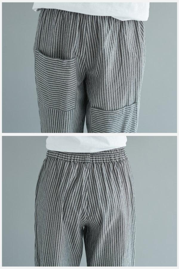 Close-up of high waist striped comfort pants with pockets and elastic waistband in gray and white stripes