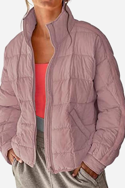 Lightweight puffer travel jacket in mauve color worn with casual outfit, warm and packable design
