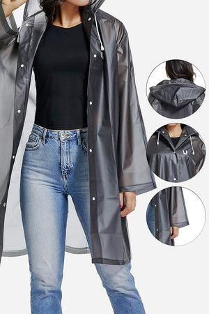 Chic Drizzle Defender black transparent raincoat with hood and snap buttons on model wearing jeans and black shirt