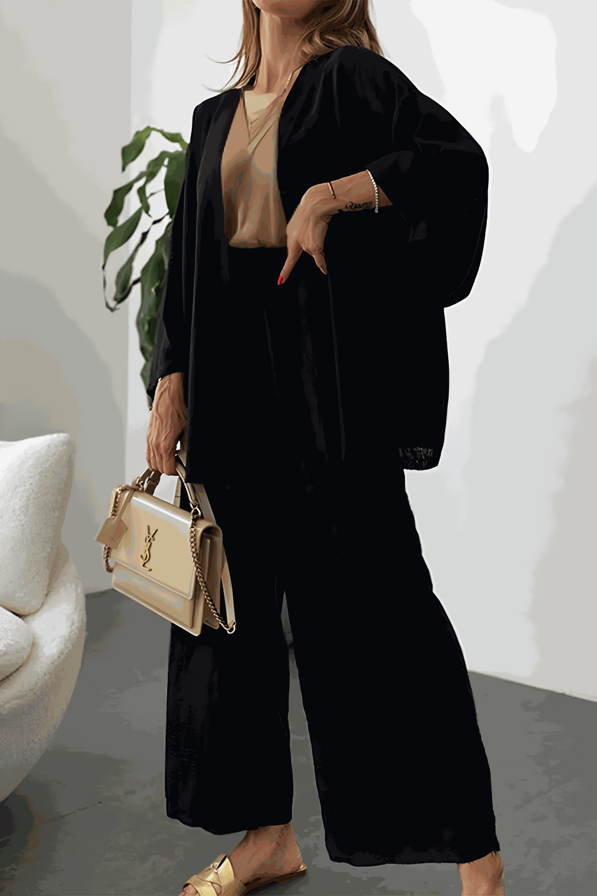 Woman wearing black Chic Comfort Kimono two-piece set with beige top and beige handbag, indoor setting