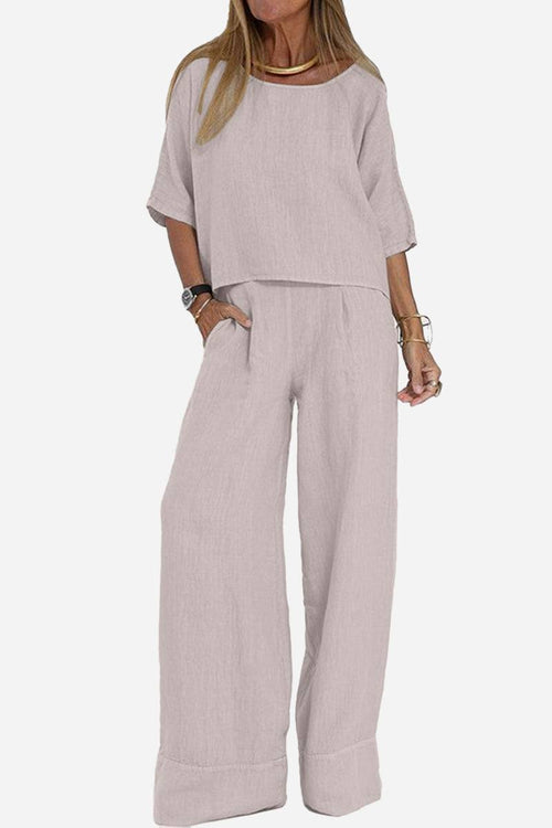 Woman wearing light-colored short-sleeved pullover and wide trouser matching set with loose fit and deep pockets