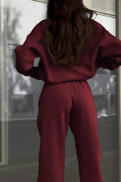 Back view of a woman wearing a maroon cotton-blended two-piece tracksuit outdoors.