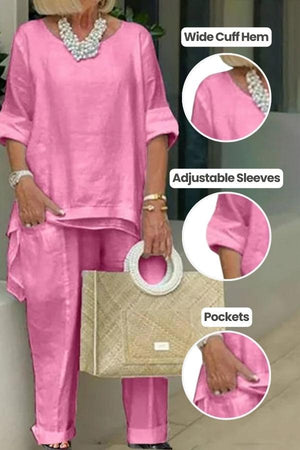Pink asymmetrical two-piece trouser set with wide cuff hem, adjustable sleeves, and pockets, made from breathable silky fabric.