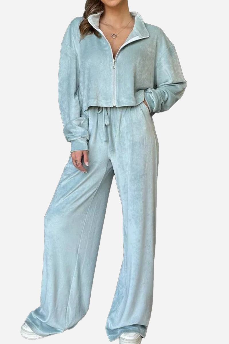 Woman wearing light blue zip up cropped jacket and wide leg pants leisure co-ord set in velour fabric