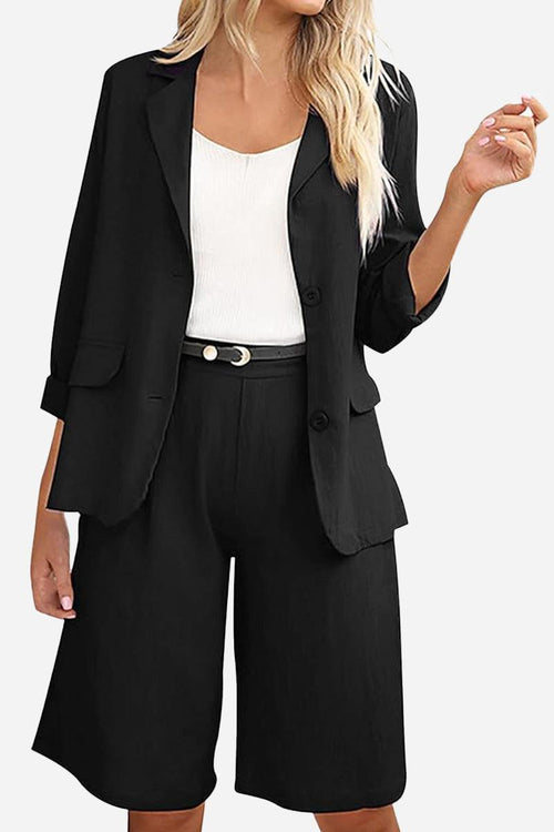Black blazer and high-waisted shorts two-piece set with a white top, featuring a tailored fit and rolled-up sleeves.