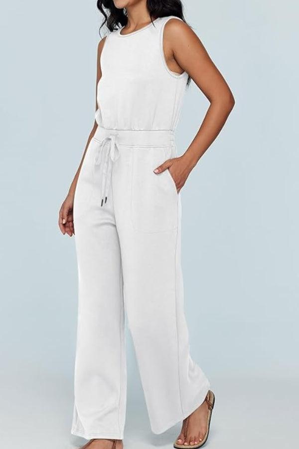 Woman wearing white sleeveless wide leg pants jumpsuit with drawstring waist and pockets