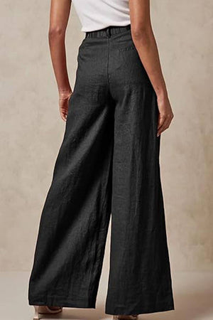 Black wide leg high waist trousers with elastic waist and pockets shown from the back