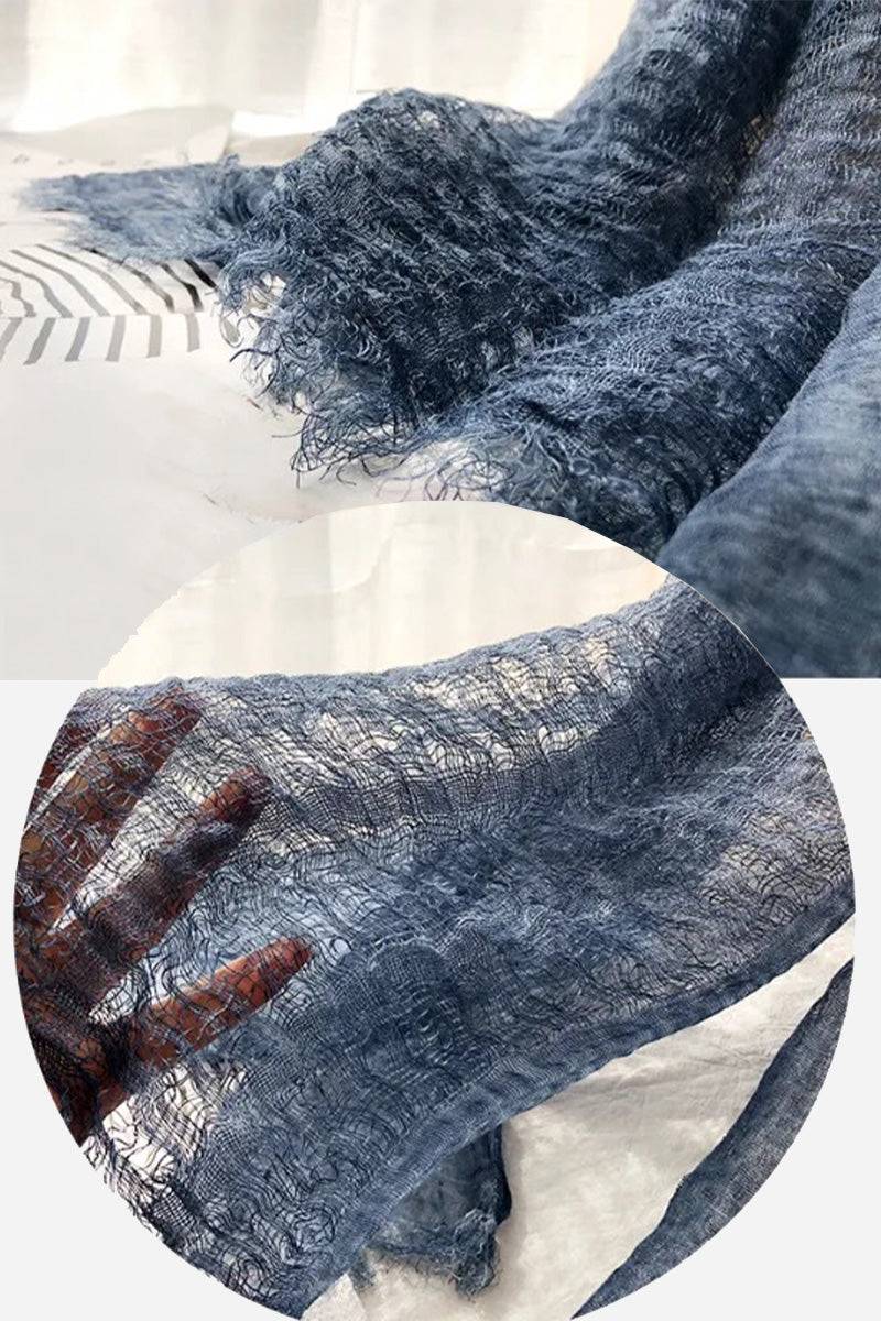 Lightweight linen scarf in soft blue with frayed edges, breathable and versatile fabric shown close-up