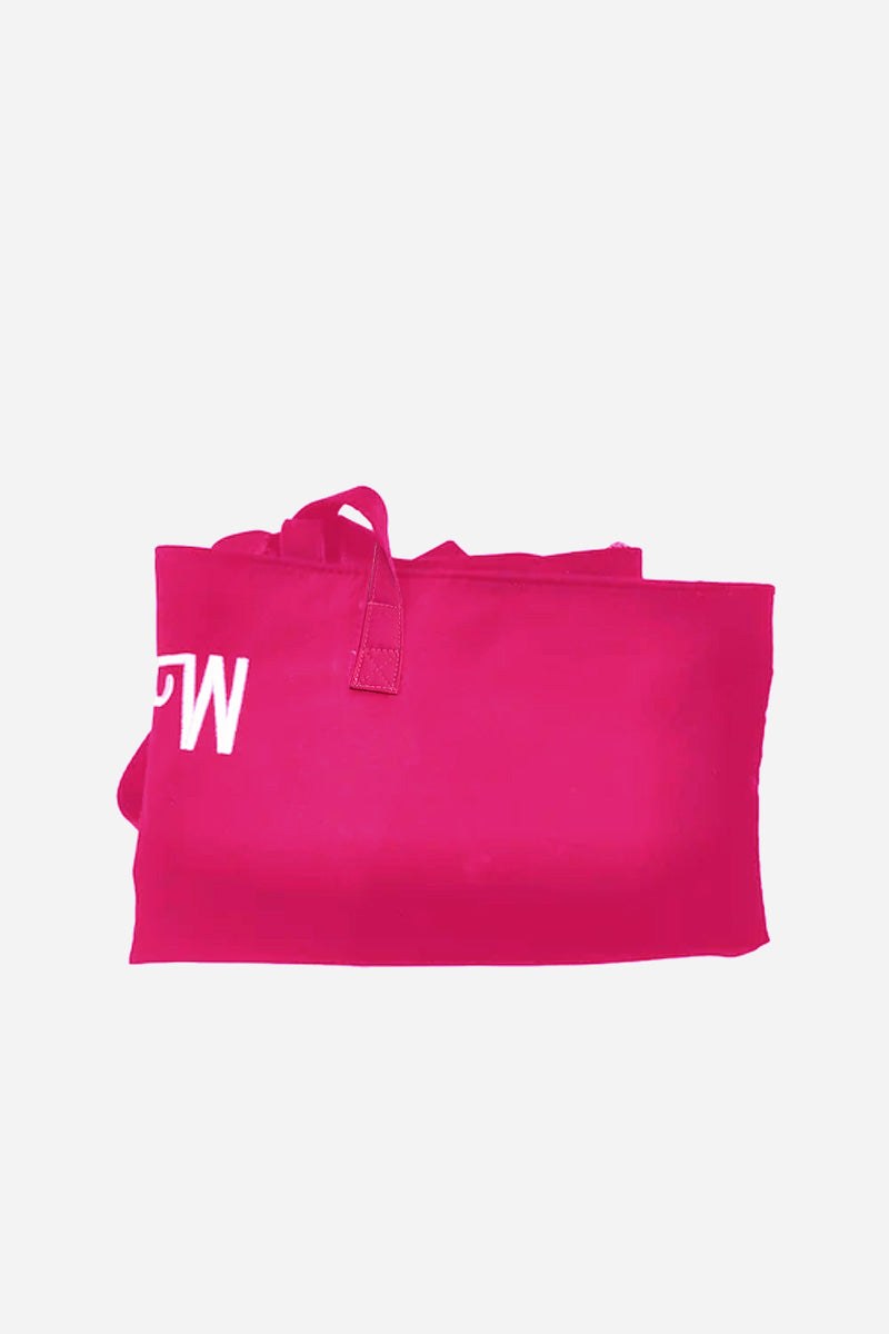 Folded bright pink waterproof travel bag with visible stitched handles and partial white letter print.