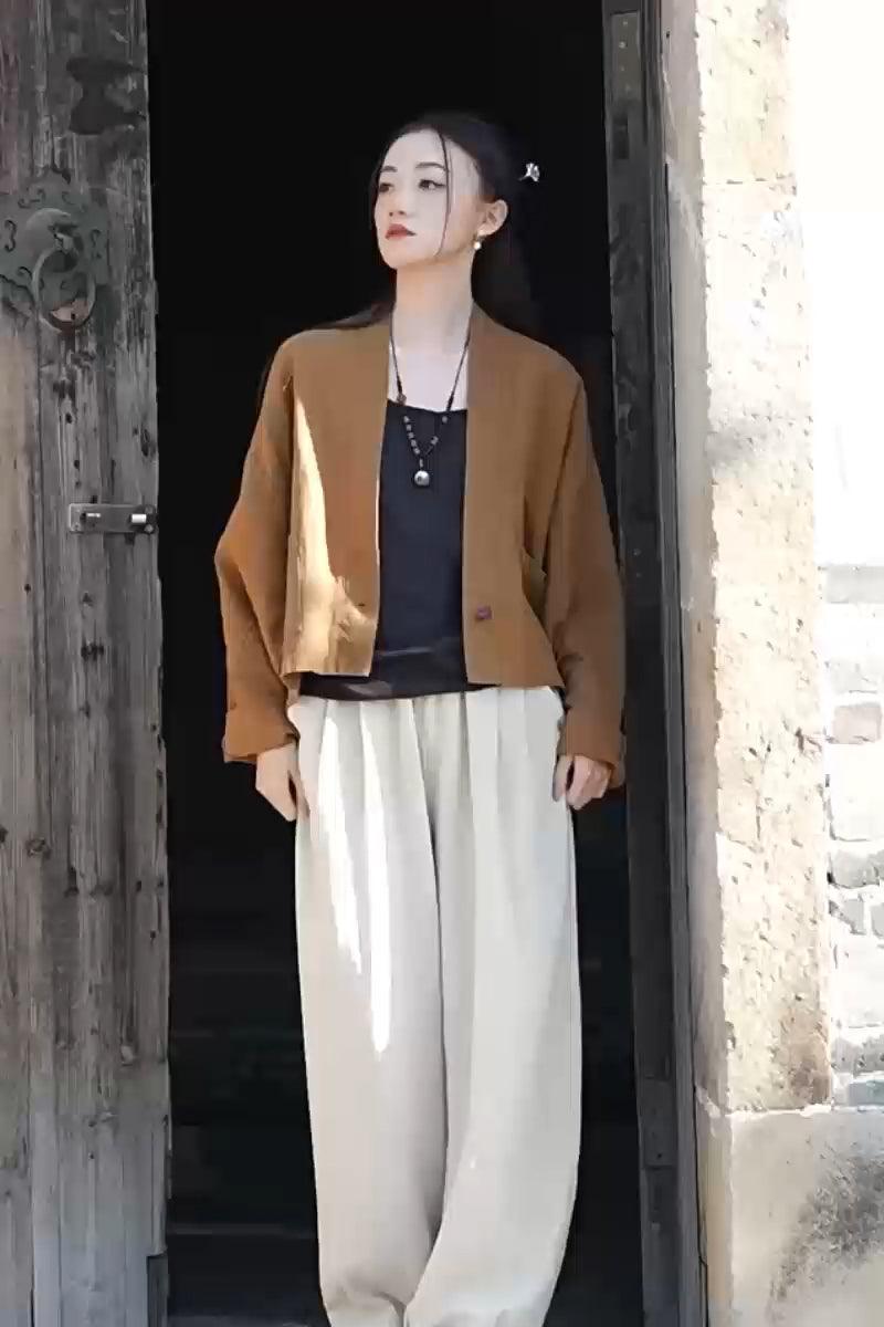 Woman wearing a warm brown ramie linen and cotton cardigan with an open front and relaxed fit outdoors