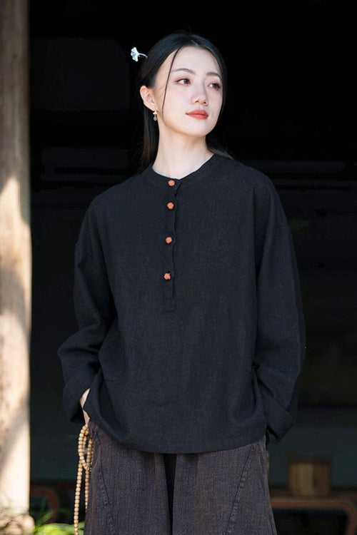 Woman wearing black ramie linen and cotton blouse with long sleeves and buttons