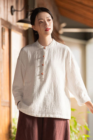 Woman wearing white ramie linen and cotton blouse with long sleeves and wooden buttons