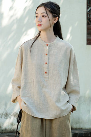 Woman wearing a one size fits all ramie linen and cotton blouse with long sleeves and buttoned front in beige tone