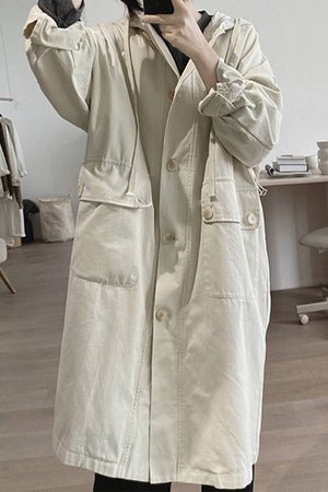 Cream-colored travel-ready hooded windbreaker made of breathable cotton with snap-button front and large pockets.