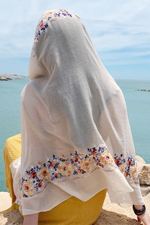 Lightweight embroidered travel-must shawl with floral border worn at seaside
