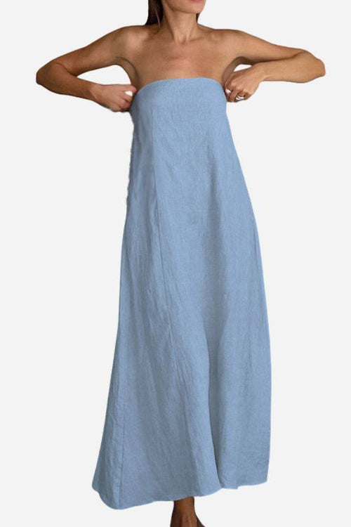 Woman wearing strapless light blue cotton linen blend maxi dress adjusting top hem