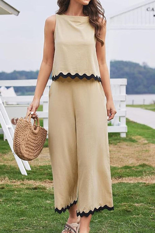 Beige scalloped trim sleeveless top and wide leg pants set with black edges on hem, stylish casual summer outfit with woven handbag.