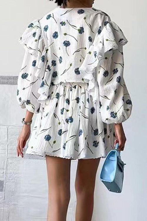 Back view of woman wearing Sweet Countryside 100% cotton ruffled two-piece set with floral print and puff sleeves, holding blue handbag
