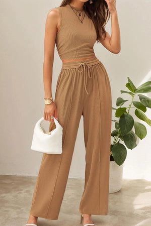 Woman wearing tan Stroll & Hangout Ribbed Knit sleeveless top and wide-leg pants two-piece set holding white handbag