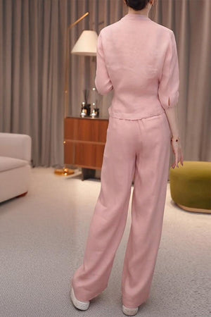 Woman wearing breathable cotton-linen pink wrap top and wide leg pants set standing indoors
