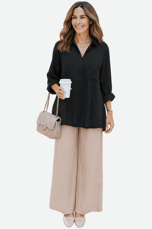Woman wearing black oversized linen blend shirt and beige palazzo pants from Oversized Linen Leaved-IN Set, holding coffee cup and beige quilted handbag.