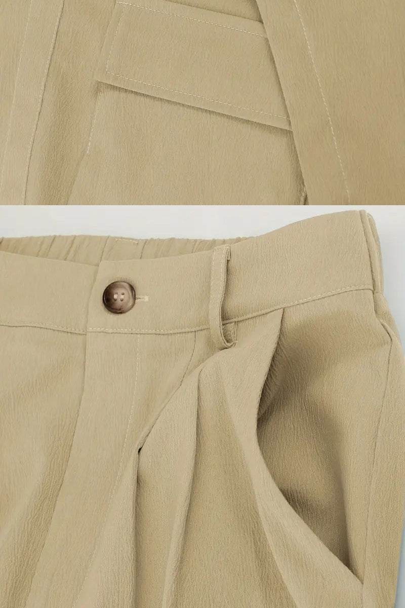 Close-up of beige two-piece set pants featuring large functional pockets and a button closure with elastic waistband.