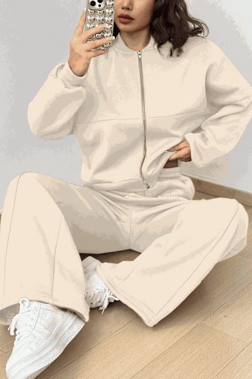 The Voyager Zip Set cream zip-front sweatshirt and wide-leg joggers travel outfit with pockets and white sneakers