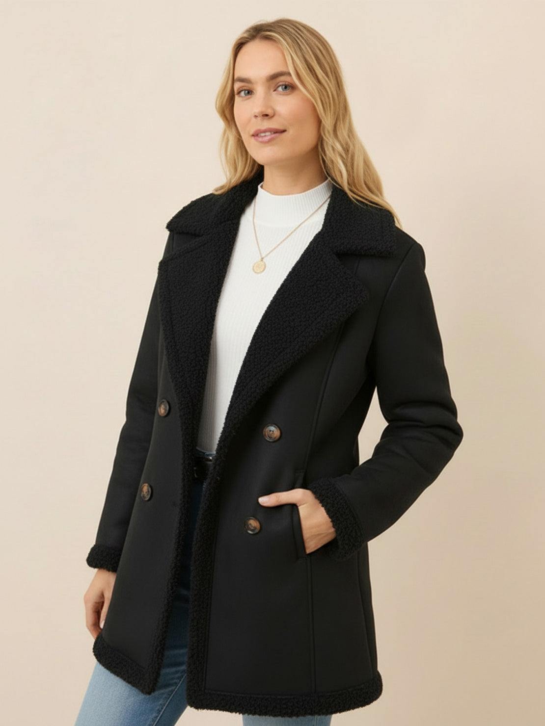 Woman wearing mid-thigh faux suede sherpa coat with double-breasted front and side pockets
