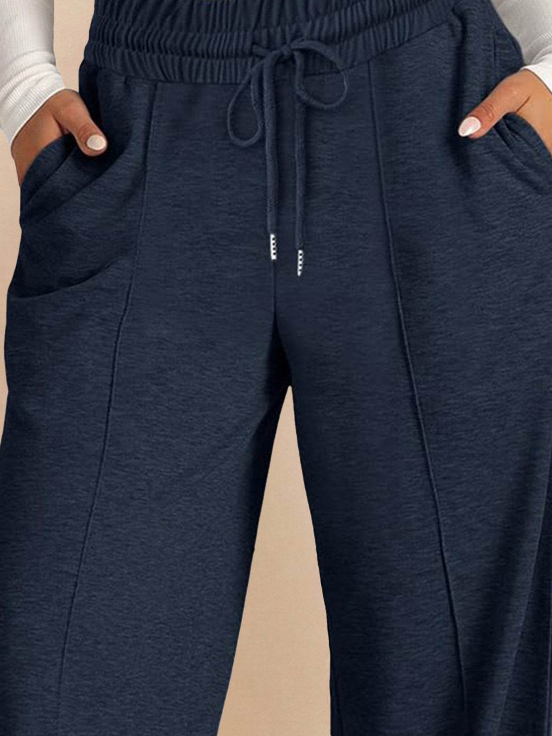 Soft knit wide-leg pants in breathable fabric with elastic drawstring waist and side pockets.