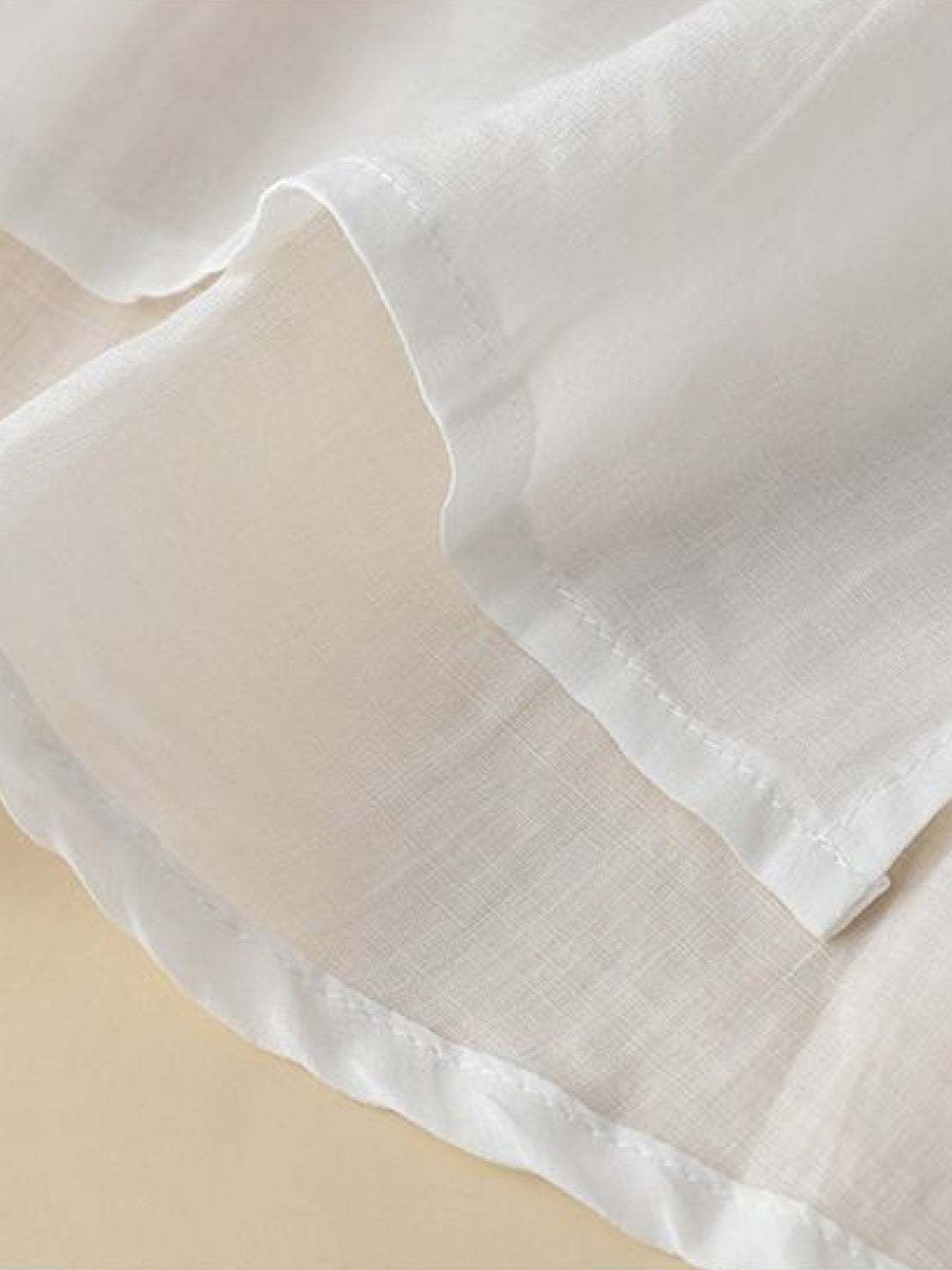 White 100% cotton linen hand-embroidered shirt with 3/4 flared sleeves and asymmetric hem