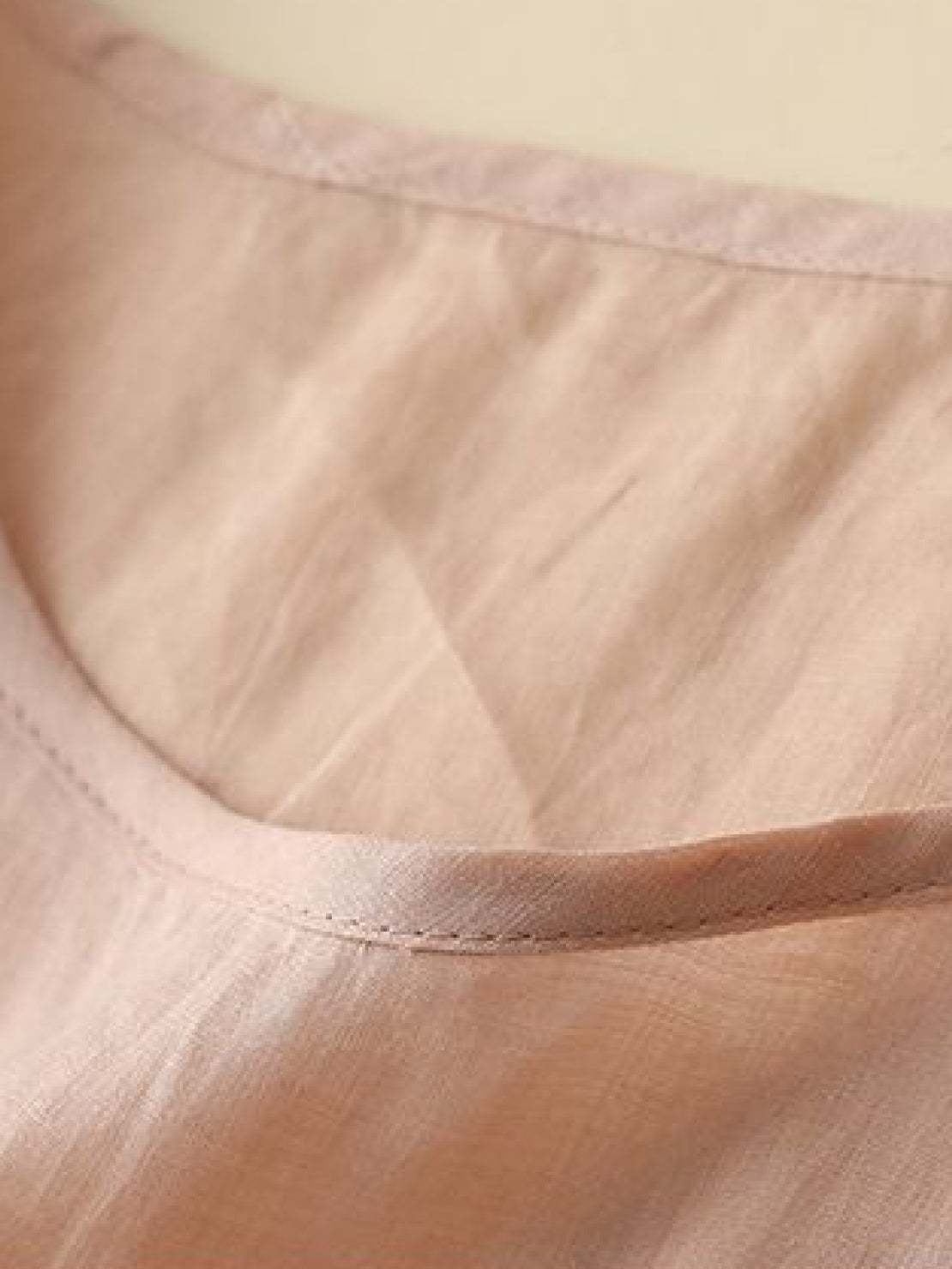 100% cotton linen hand-embroidered shirt with 3/4 flare sleeves and asymmetric hem featuring dense botanical embroidery