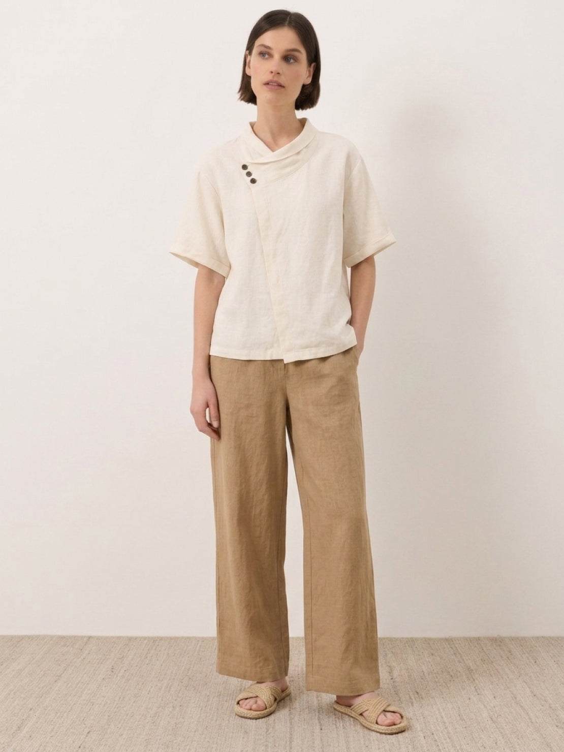 100% linen top with relaxed V-neck, asymmetric buttons, short sleeves, and breathable fabric in navy blue, pastel pink, and cream colors