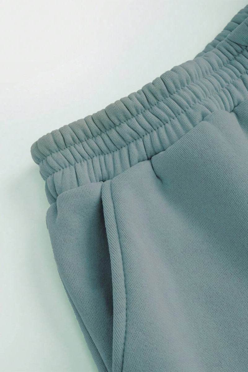 Woman wearing a comfortable cotton-blended two-piece tracksuit with high collar and deep zipper in monochrome design