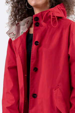 Red oversized water-resistant windbreaker jacket with hood and button closure