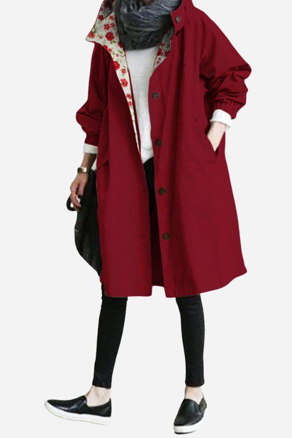 Red water-resistant oversized hooded windbreaker jacket with floral inner lining, worn with black leggings and shoes