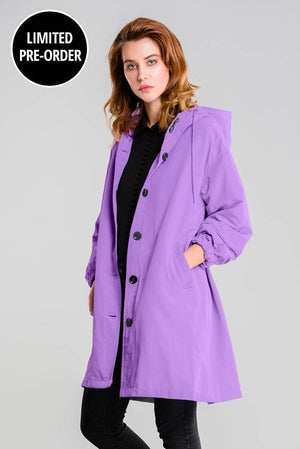 Water-Resistant Oversized Windbreaker rain jacket in purple with hood and pockets, worn by female model