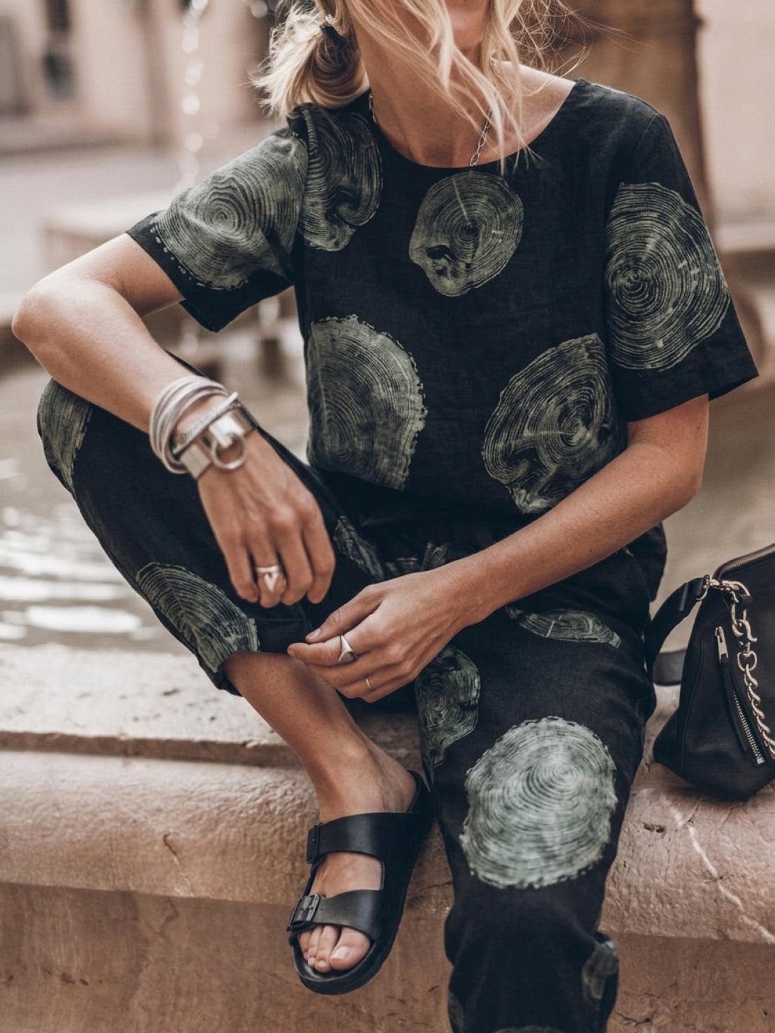 Model wearing relaxed fit cotton linen set with short-sleeve top and straight-leg pants in monochrome tones