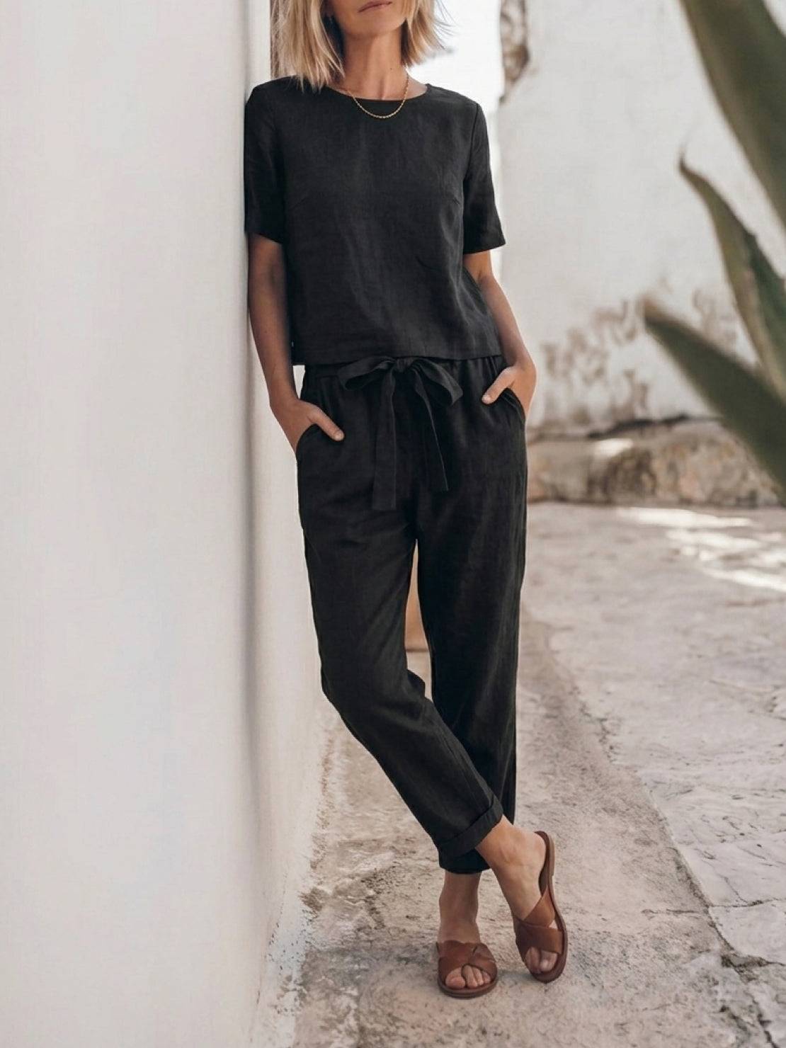 Woman wearing relaxed 100% cotton linen set with short-sleeve top and straight-leg pants in monochrome tones