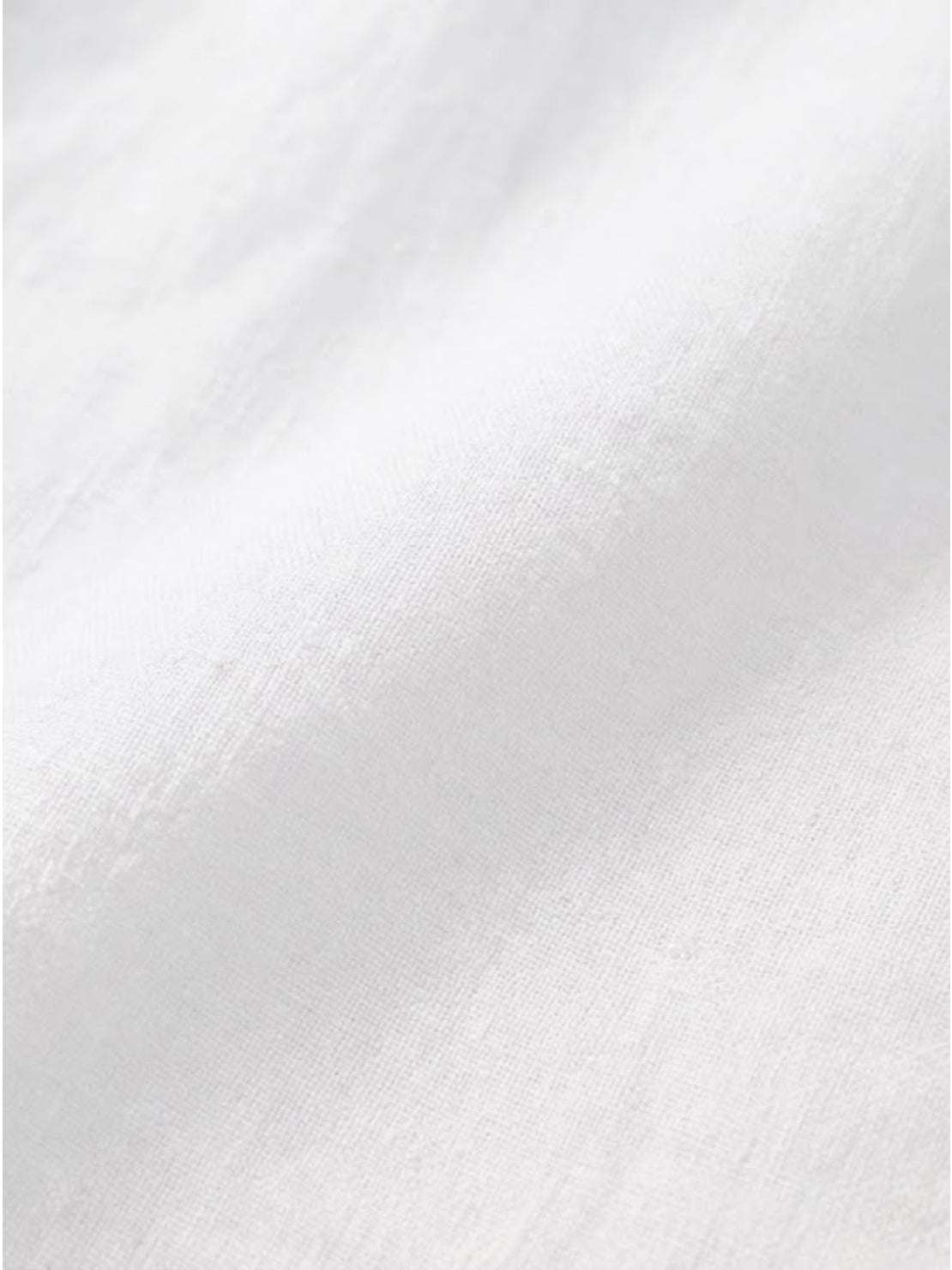 Close-up of soft, breathable white pure linen fabric for age-defying button detail shirt