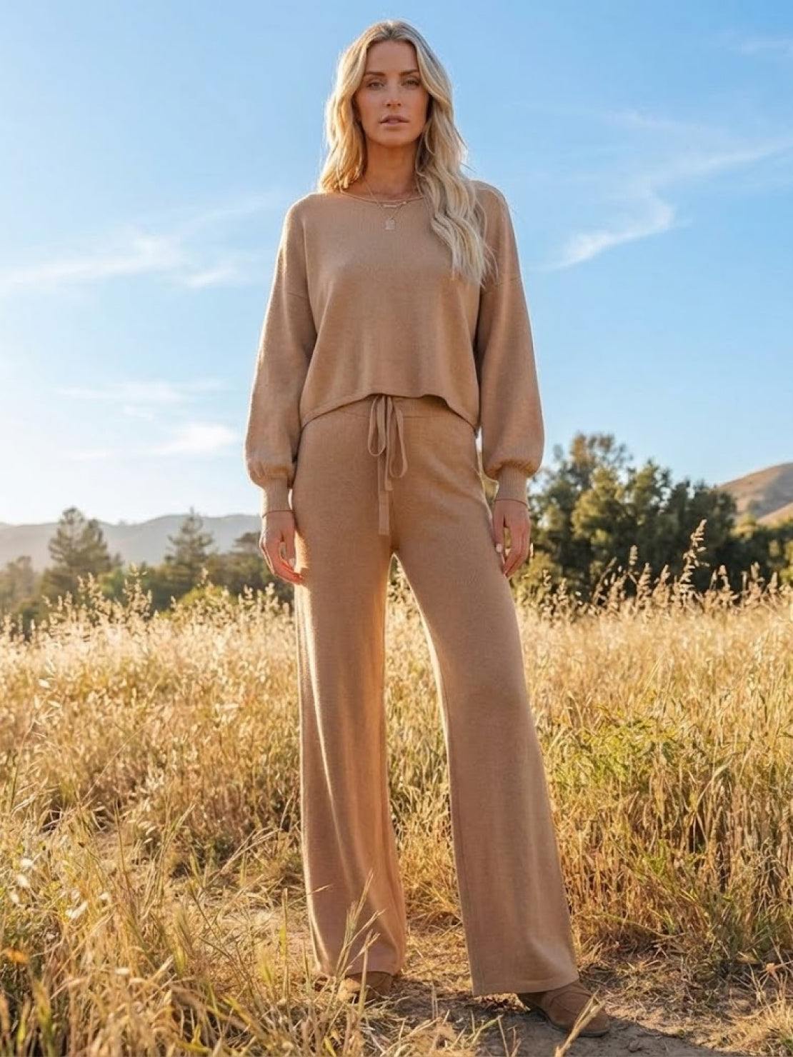 Woman wearing a beige round neck loose fit cozy two-piece set standing outdoors in a field