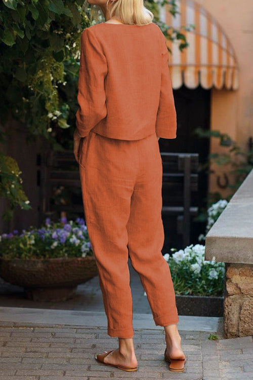 Back view of relaxed cotton-linen monochrome set with longline top and wide-leg pants in rust color.