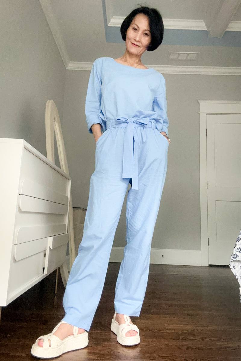 Woman wearing light blue cotton-linen monochrome longline top and wide-leg pants set with white sandals indoors
