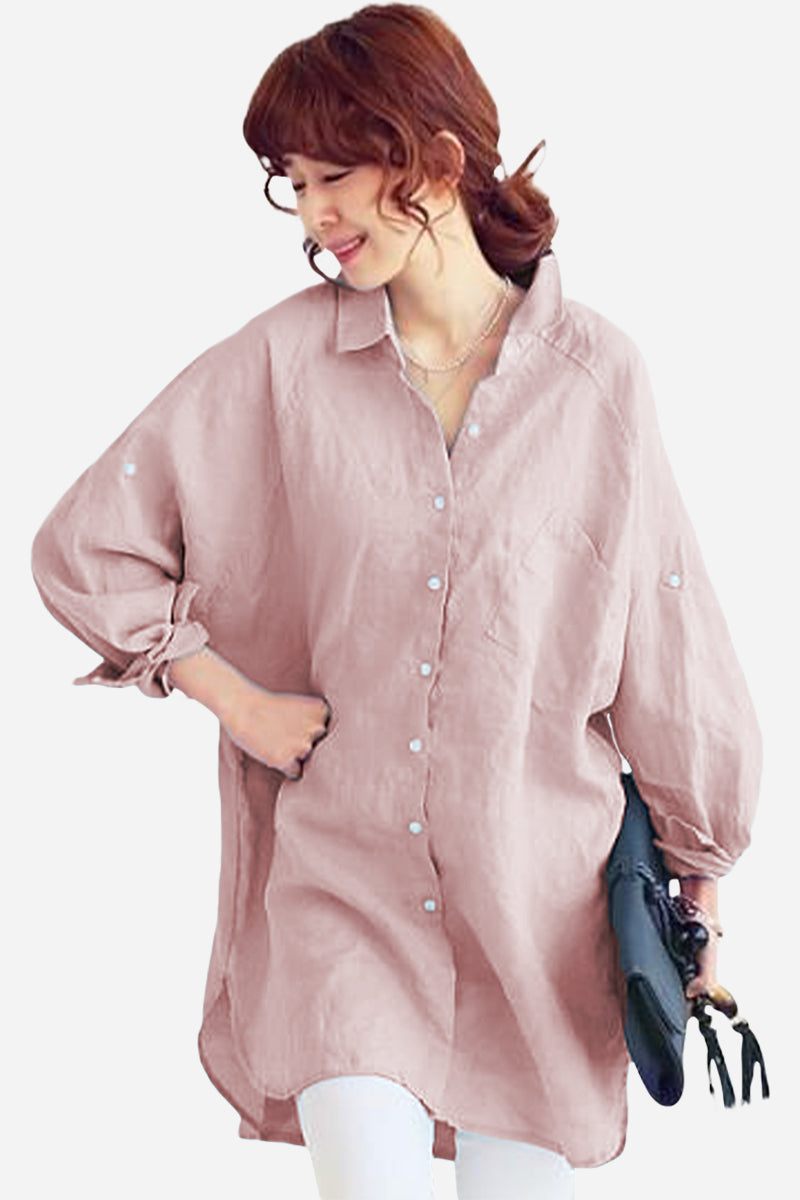 Woman wearing oversized pink linen shirt with long sleeves and buttons, holding a black bag