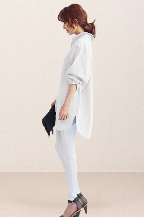 Woman wearing oversized white linen shirt with rolled sleeves and high-low hem